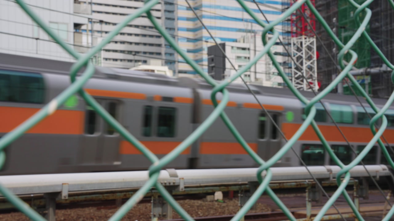 Tokyo City Establishing Shot, Crowded Urban Environment, Reveal From Chain Fence