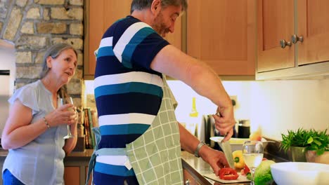 Side-view-of-old-caucasian-senior-man-cutting-vegetable-in-a-kitchen-4k