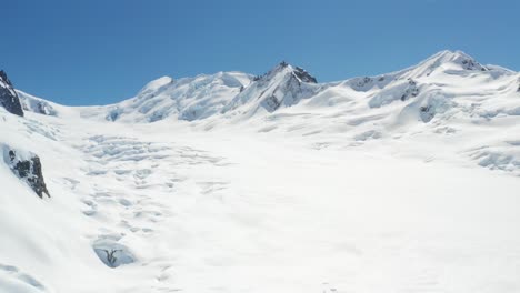 imágenes de drones de 4.000 metros sobrevolando un enorme campo de hielo glacial con montañas escarpadas de fondo