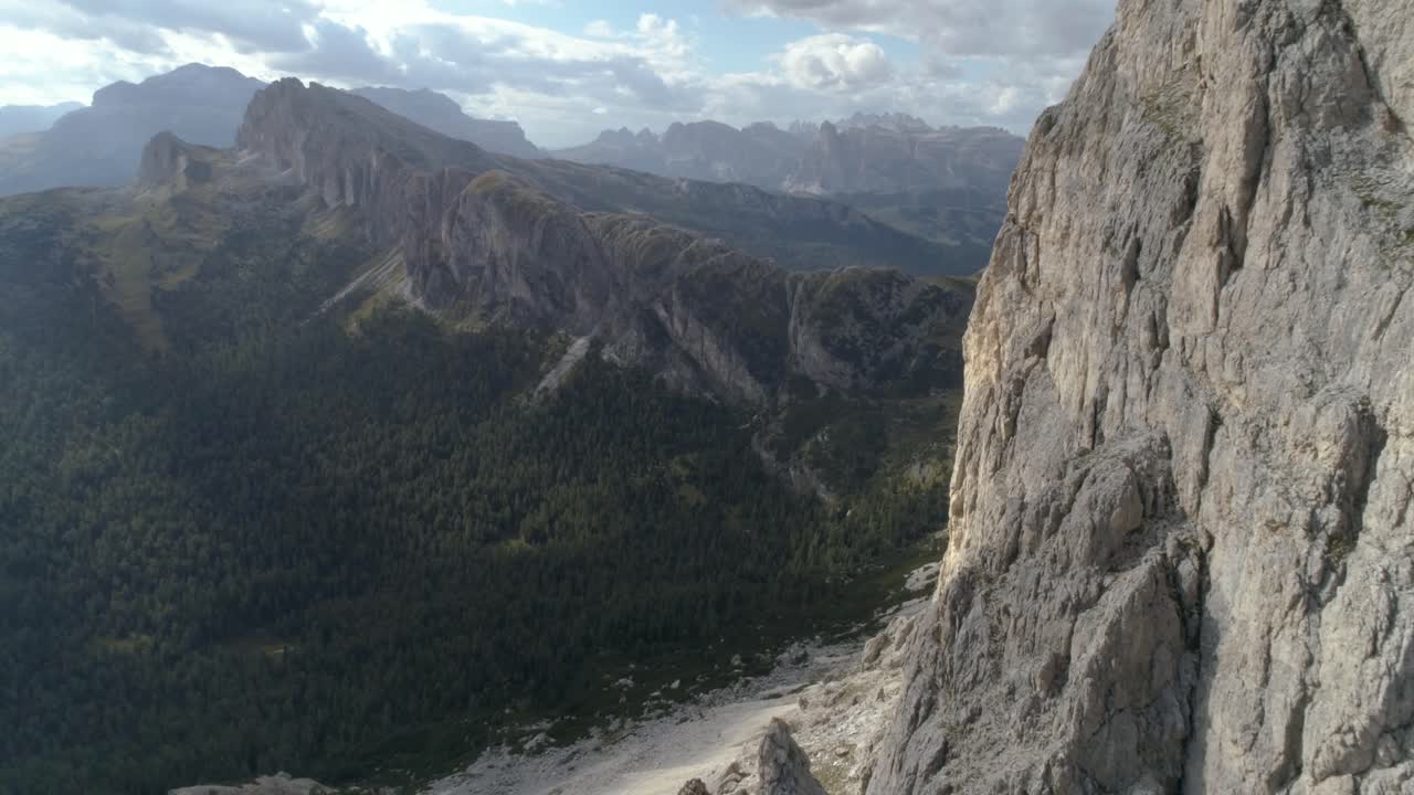 vuelo aéreo épico cerca de la cima de una montaña en los dolomitas italianos, revelando más en el fondo.