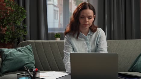 mujer trabajando desde casa en una computadora portátil