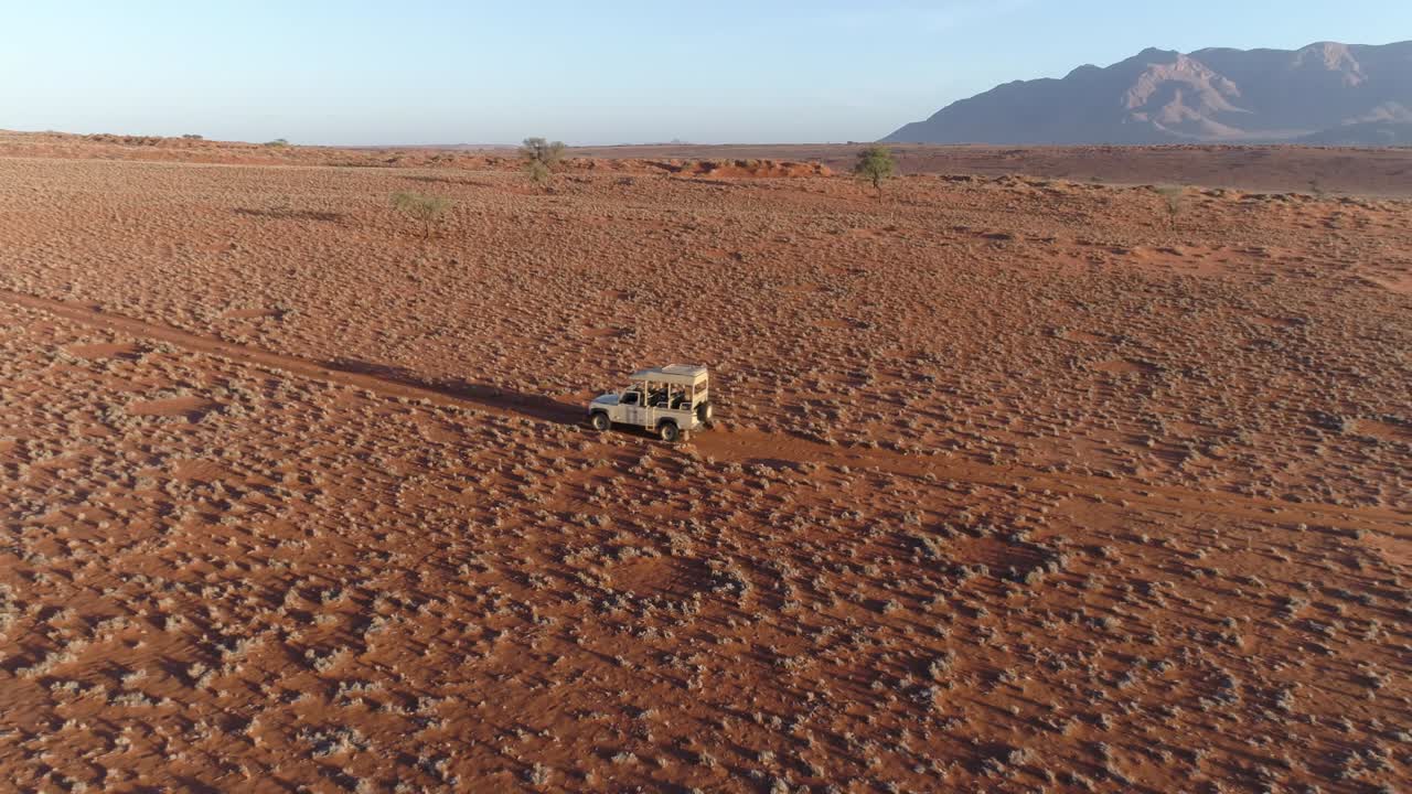 vista aérea de un vehículo de safari conduciendo a través de los famosos círculos de hadas de namibia