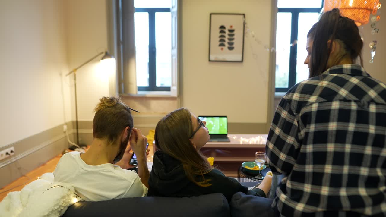 친구들이 tv를 보고 스마트폰을 사용하고 있습니다.