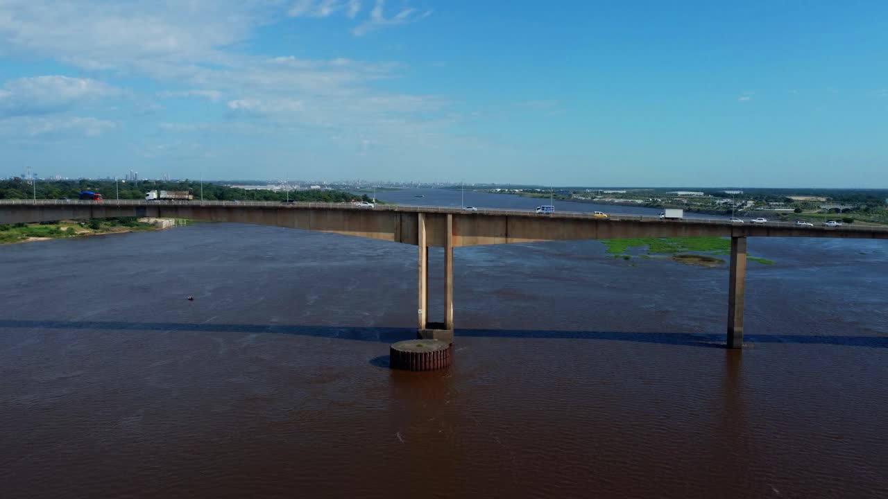 puente de haz largo con abundante tráfico sobre una enorme masa de agua, vista aérea