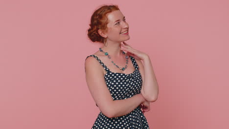 cheerful lovely redheaded young woman fashion model in dress smiling and looking at camera alone