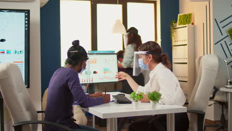 manager talking with african employee about company statistics