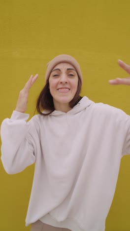 woman in beanie making hand gestures