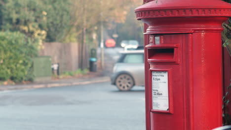 red post box by busy road junction with traffic