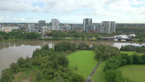 Avance-Aéreo-Volando-Hacia-El-Barrio-Sobre-El-Parque-Y-El-Río