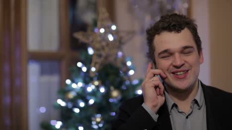 young man smiling while talking on the phone