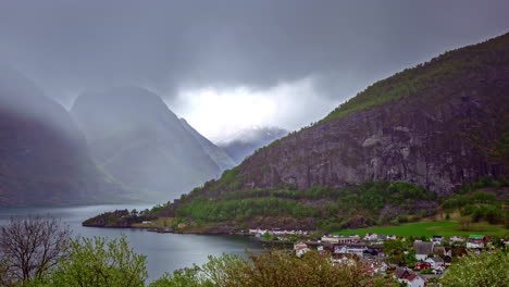 Timelapse:-Clouds-Sweeping-Over-Lakeview-in-Flam-Village,-Norway,-Amidst-Heavy-Rain,-Dark-Clouds,-and-Majestic-Snowy-Mountains