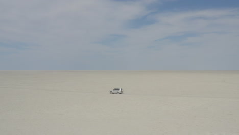 suv car driving on dry kubu island in the makgadikgadi pan area of botswana