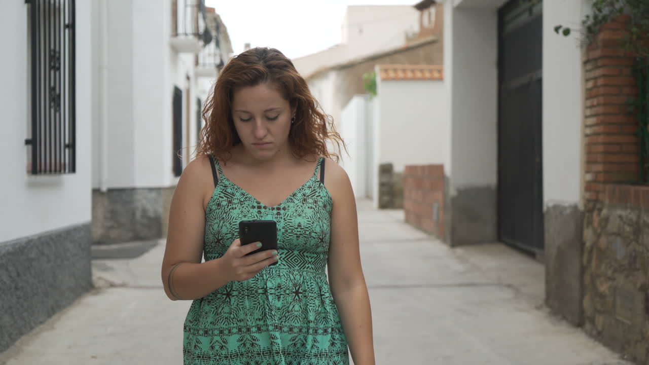Mulher com Celular Caminhando na Rua