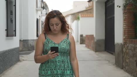 woman with phone walking on a street