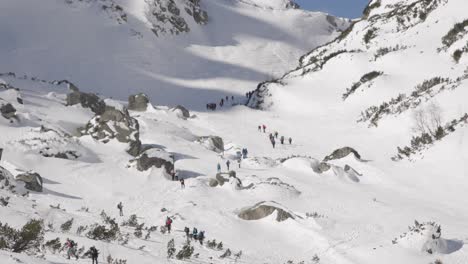 Mountaineers-Ascend-the-Rocky-Snow-Covered-High-Tatras,-Slovakia-in-Winter