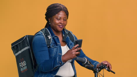 Woman-Checks-Cell-Phone-While-On-Bicycle