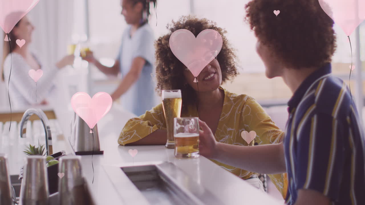animación de iconos de corazón sobre felices amigos diversos bebiendo cerveza
