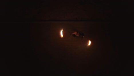 Aerial-Young-male-does-tricks-with-fire-spins-two-burning-torches