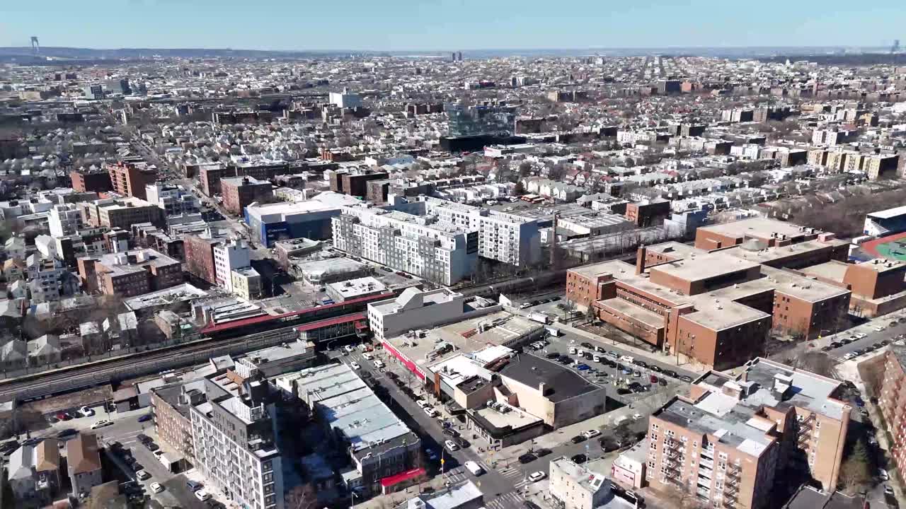 Horizontal drone circling orbit shot over Avenue M in Brooklyn, capturing the city's vibrant streets, residential buildings, and dynamic urban landscape with smooth aerial motion.