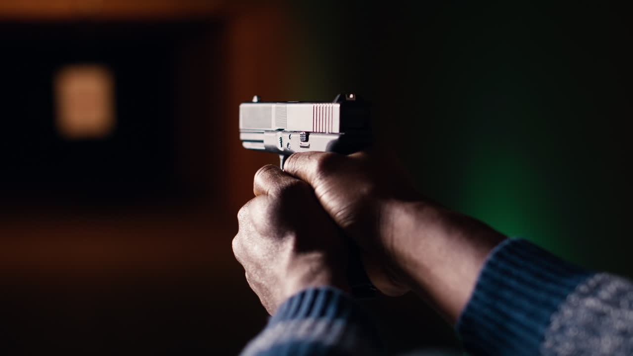 Shooting range client shoots with pistol, engaging targets, close up