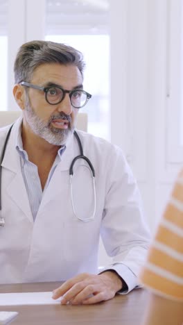 doctor writing down notes and talking to a woman