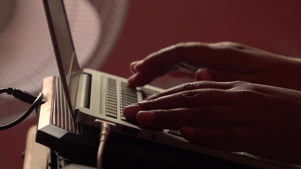 Hands typing on a portable computer