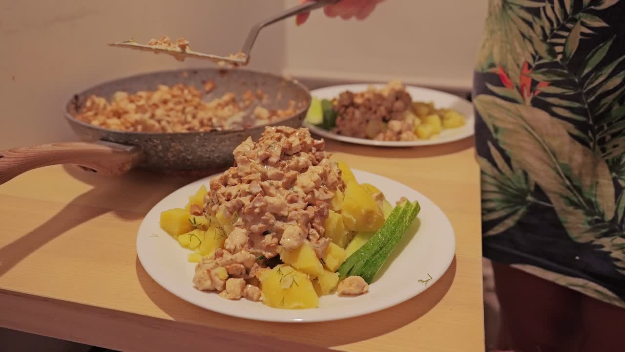 Homemade chanterelle sauce and meat poured over potatoes on plate, cozy kitchen