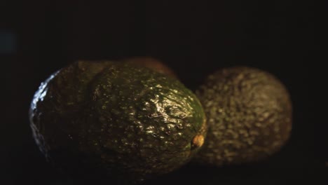 macro shot of slow rotating avocados with black background lighted in professional studio