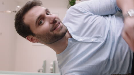 attractive-caucasian-man-having-video-chat-using-smartphone-at-home-showing-off-hairstyle-chatting-sharing-lifestyle-enjoying-online-communication-on-vertical-screen