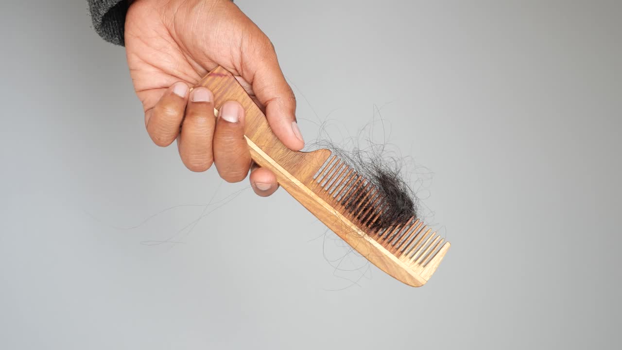Hand holding a comb with a large amount of fallen hair