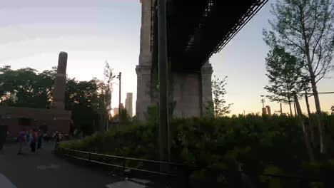 person walking through brooklyn bridge park under the