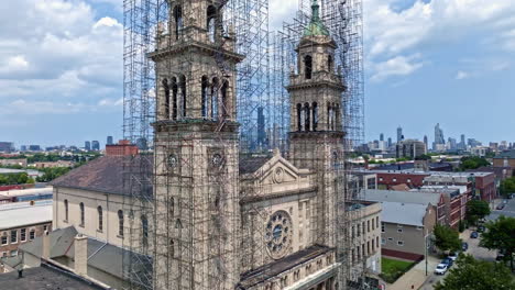 Aerial-view-ascending-in-front-of-the-St-Adalbert-Church,-revealing-the-skyline-of-Chicago