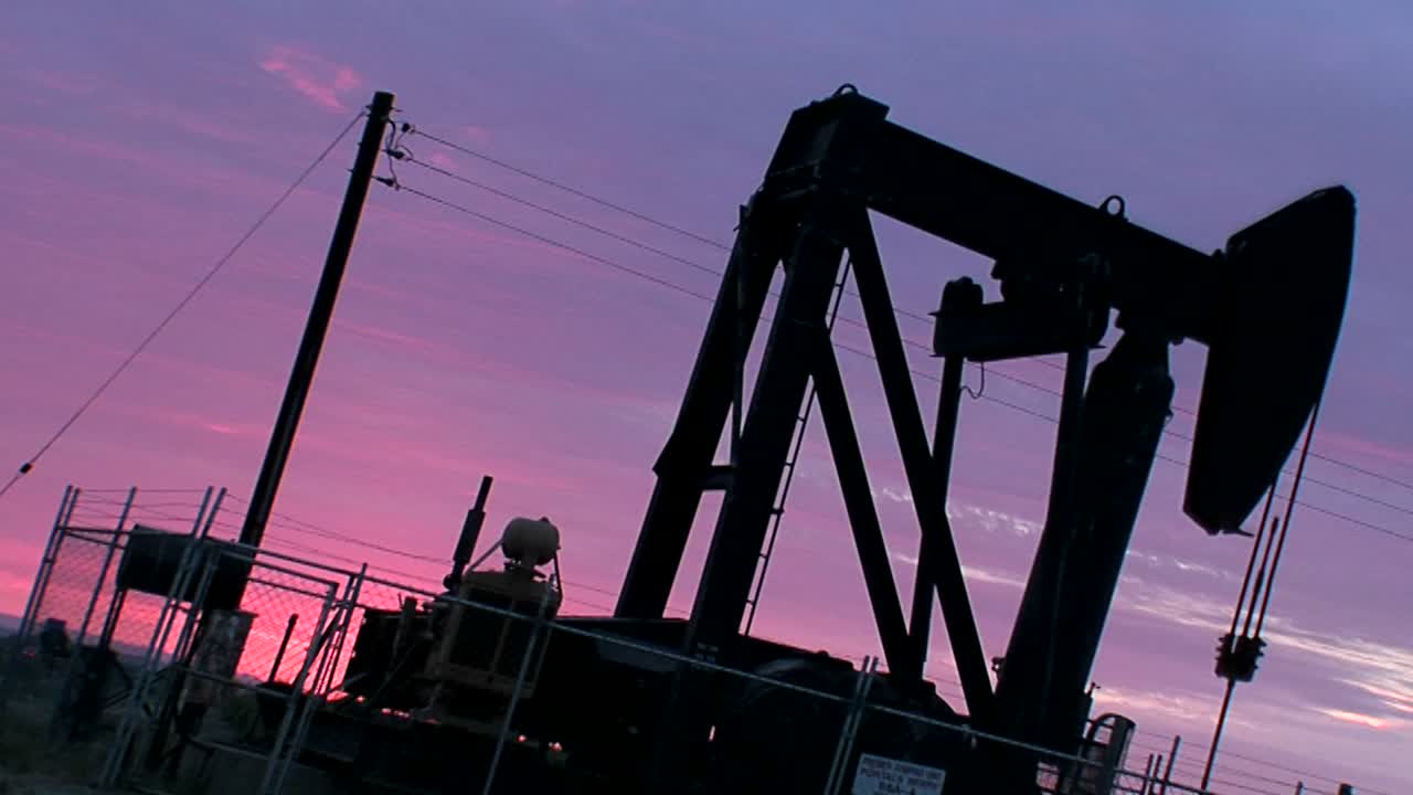 보라색 하늘을 배경으로 오일 데릭 펌프