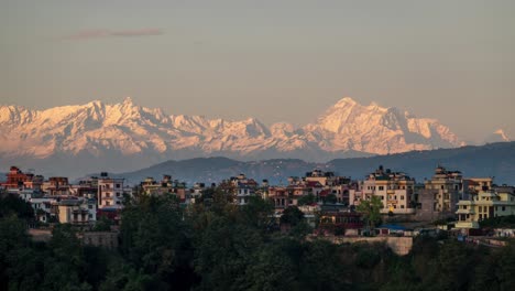 a time-lapse of the sun setting over the himalaya mountains and the city of kathmandu, nepal.