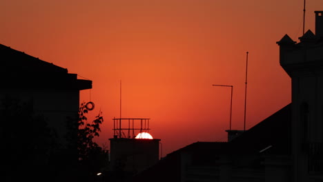 golden hour sunset behind a building with red sky in nazare, portugal - close up