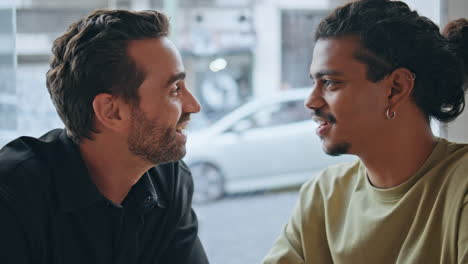 homosexual men speaking coffee house looking each other with sympathy closeup