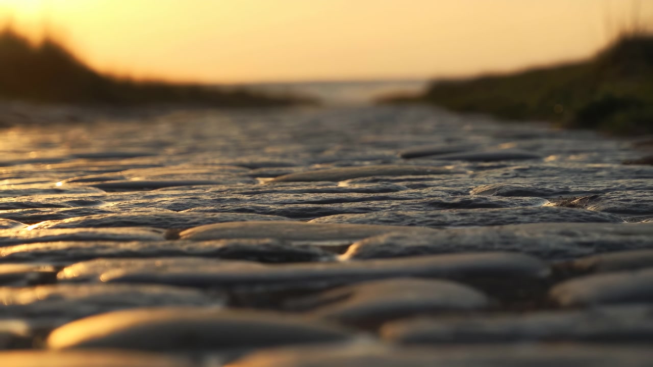 Ripples on water surface no visible action static scene, in sunset or sunrise with a mountainous landscape in, with water, mountains, with water, rocky terrain texture, with golden, blue accents.