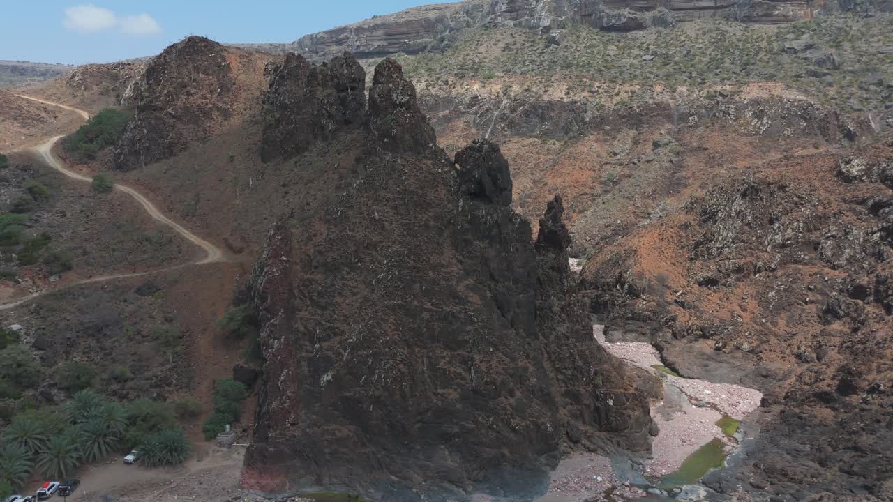 vista aérea de un paisaje árido y escarpado con un río que fluye a través del valle en socotra