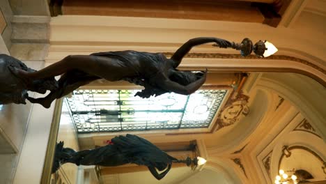 vertical shot of sculptures holding lamps inside the museo de arte tigre in buenos aires, argentina