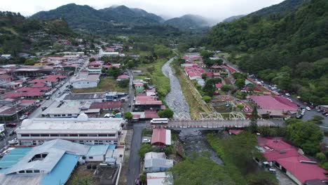 aerial view of a mountain town nestled in a valley with a winding river and bridge