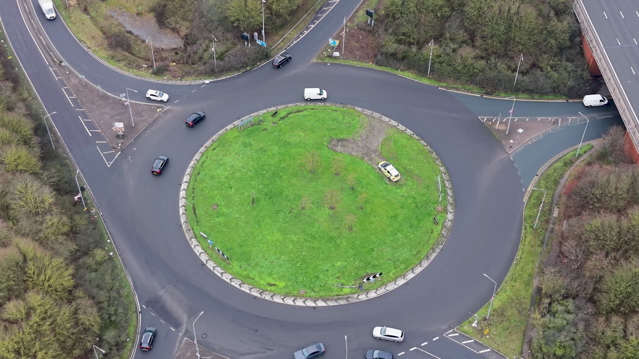 Drone mundur di bundaran Waltham Abbey dengan lalu lintas dan mobil Dinas Jalan Raya