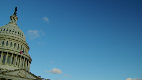 the camera pans left and settles on the dome of the us capitol building in dawn sunlight