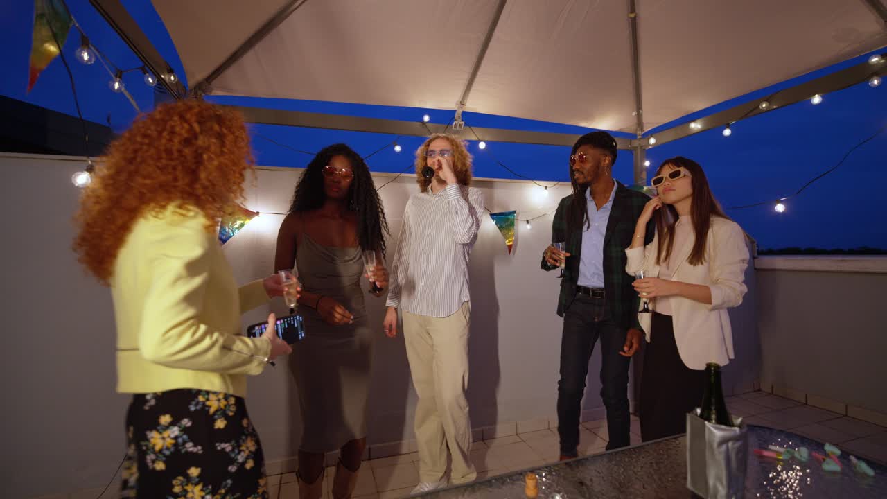 Group of friends celebrating on a rooftop at night