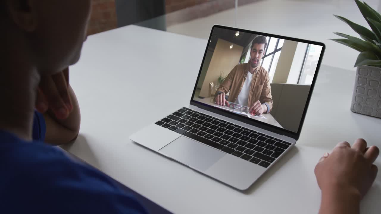Mid section of african american woman having a video call on laptop with male colleague at office