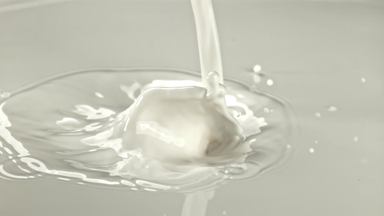 Slow Motion Pouring Milk Creating Splashes and Ripples