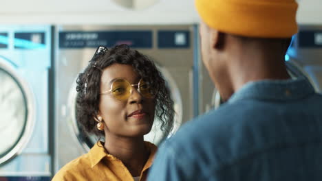 close up of young girl and guy meeting and hugging at laundry service room