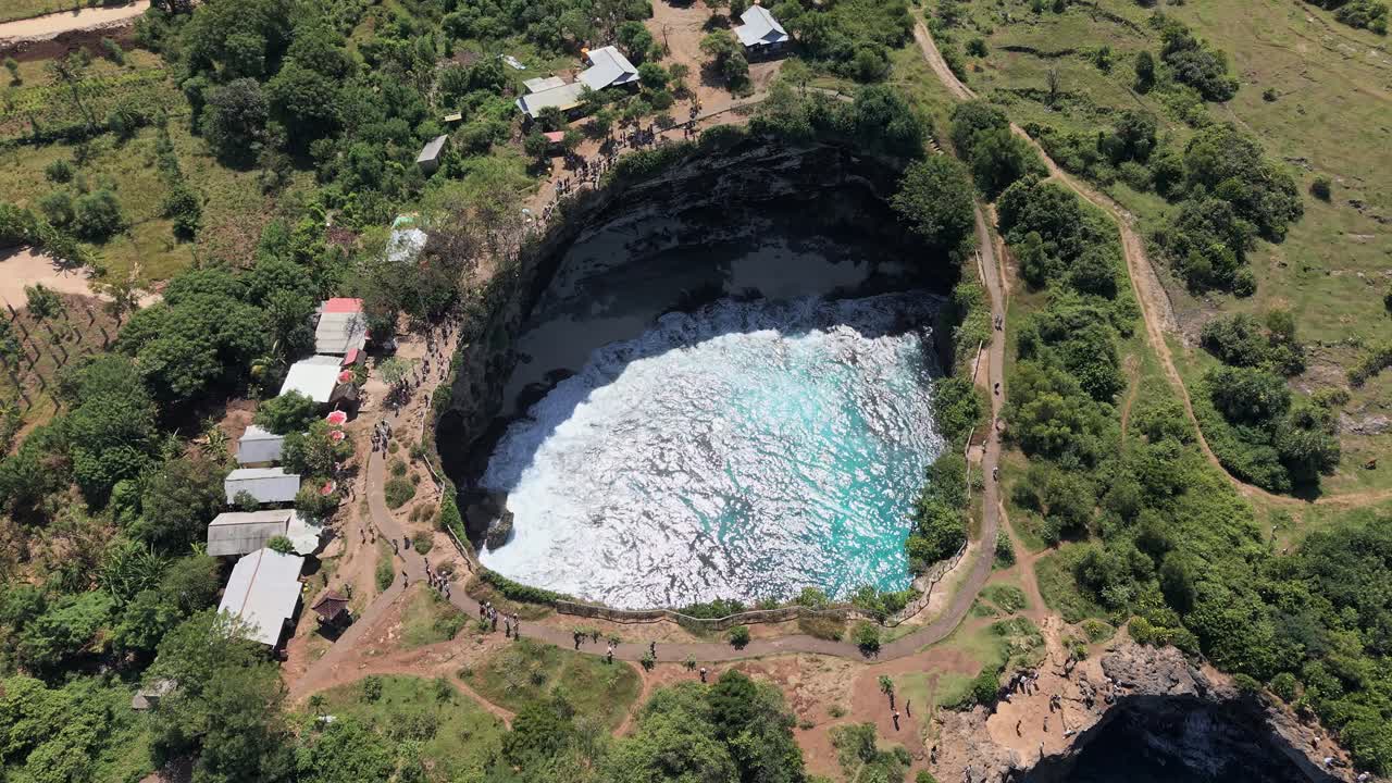 Drone flying over the unique circular cliff formation of Broken Beach, Nusa Penida