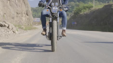 man riding a motorcycle on a scenic road