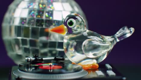 a charming glass bird spinning records beside a sparkling disco ball, capturing the joy of music and dance in a colorful display