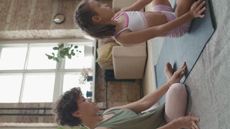 mother and daughter practicing yoga at home